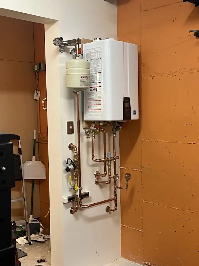 Plumbing technician inspecting water heater connections in Lockwood